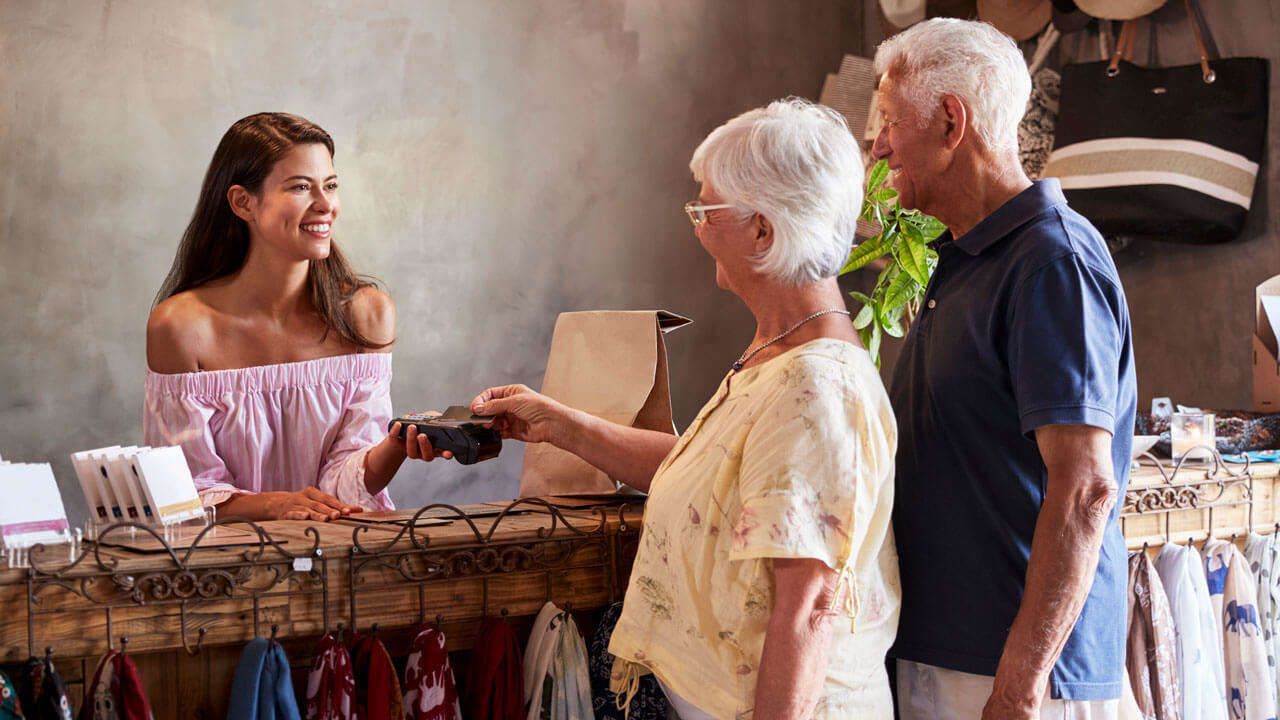 Customer Service Associate Smiling at Happy Customers at Check out Counter